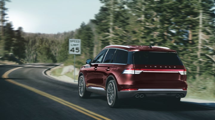 A 2024 Lincoln Aviator® SUV is being driven on a winding mountain road | Sentry Lincoln in Medford MA